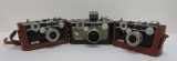 Three vintage Argus 35 mm cameras with leather cases