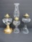 Three vintage oil lamps, clear and one with reverse painted stem, 9 1/2