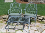 Two heavy metal outdoor patio chairs with rectangular glass top table
