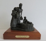 Cast metal sculpture, mother and children gathered by a well, 9