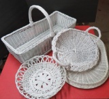 Four white wicker baskets and trays