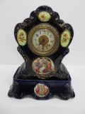 Cobalt and gold porcelain clock and stand, woman in garden and floral, Stoke on Trent