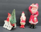 Two celluloid Santa figures and clay face Santa in sleigh