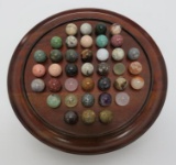 Agate and quartz marbles with wood solitaire board