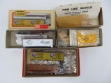 Three Schlitz HO scale train cars and two unassembled wooden train car kits