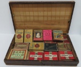 16 Vintage cigarette packs, empty, and one cigarette tip in wood box