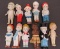 10 bisque penny dolls and one plastic black americana doll, 3