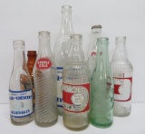 8 vintage soda bottles, 7 oz to 32 oz