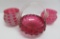 Three pieces of patterned cranberry glass, all have some damage