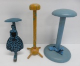 Three vintage hat stands, one is metal table clip on
