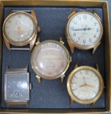 Four vintage Bulova men's wrist watches and one women's, no bands