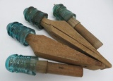 Four blue glass Hemingray insulators on wooden rods