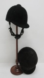 Two English riding helmets and wooden hat stand