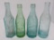 Four colored Milwaukee Area crown top soda bottles, 7 1/2