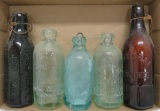 Five assorted colors and sizes of Graf bottles