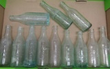 12 vintage soda bottles, aqua and clear