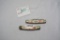 Two modern pocket knives with Trojan Country marketing message on handle, one had crack in handle, u