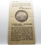 Morgan $ 1885 on Tidy House display card, toned