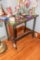 Side table with ornate carving on top (no contents)