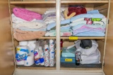Towels and items in bathroom closet and drying rack
