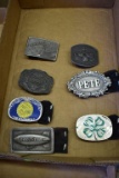 Seven belt buckles: Good Year, FFA, Larry, 1976 Farm Fest, Four wheeling, Pete, 4H