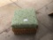 Wicker ottoman with green cushion