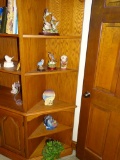 Items on 5 shelves of corner unit: statues, vase, plant.