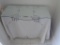 Wooden desk underneath glass top/tablecloth plus picture