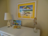 Framed umbrella picture, glass plate on stand , small nautical lamp and bottle