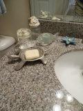 Items on sink-turtle soap holder, plastic shell glass, shell canister, fish candle holder, starfish