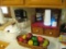 Tea maker, Serving bowl w/lid, plastic fruit basket, Simplisafe, wooden shelf w/knick knacks