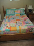 Full/double bed w/side table, chest, mirror, pictures on walls, stool, and metal rack