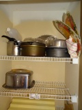 Everything on shelves; pots, pans, metal cake carrier, sifter, misc.