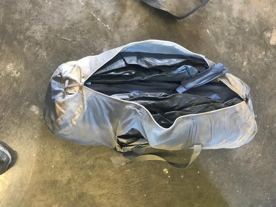 Camping tent in bag, appears to be a 10 x 10 with poles.