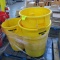 pallet of yellow Rubbermaid Brute trash cans