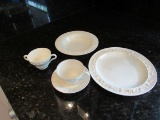 10 place setting of white china dishes includes dinneer plates, soup cup, salad bowl, cup and saucer