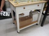 white table on casters with drawer and bottom shelf