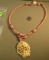 Pink silk corded necklace with pendant of 3 frogs carved from bone