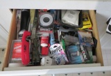 contents of kitchen drawer with a variety of goodies with tools, lighters, etc.