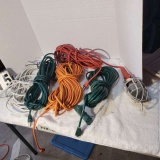 orange and green extension cords including one trouble light