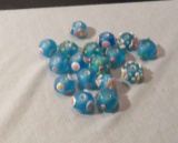 package of 17 turquoise with pink white raised design glass beads