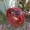 orange water hose with nozzle and metal hose stand