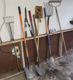 mixed yard tools including rakes and shovels