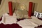 pair large red candles, pedistal cake plate with glass cover, and table runners