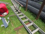 group of older fiberglass and aluminum extension ladders