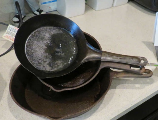 group of 2 cast iron frying pans 9"& 7" and one steel 7