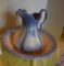 Ceramic water picture sitting in a bowl blue and white with blue flower on the front small chip at t