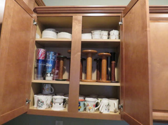 mixed cups, saucers and antique thread spools  in kitchen cabinet
