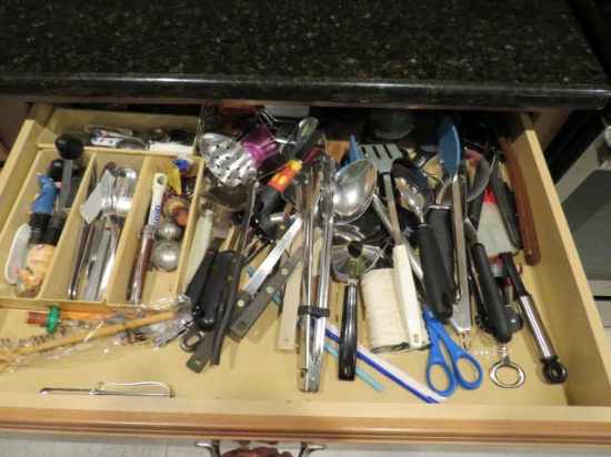 mixed kitchen utensils in kitchen drawer