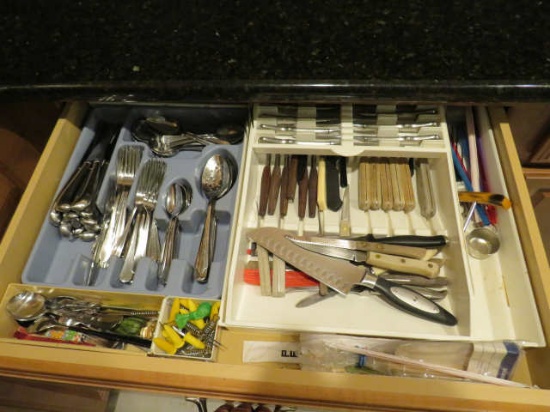 mixed knives, flatware, and serving utensils in kitchen drawer